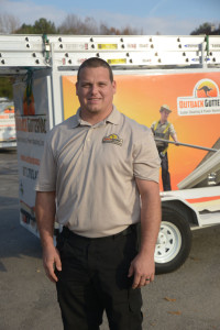 A franchise partner stands in front of his equipment trailer.