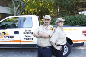 Two Outback GutterVac technicians stand in front of a branded truck.